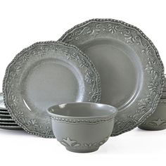 a set of gray dinnerware on a white background with an ornate design in the middle