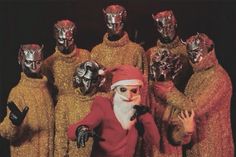 a group of people dressed up as santa claus and other characters wearing masks on their heads