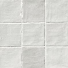 a white tile wall that has squares in the middle and one square on the other side