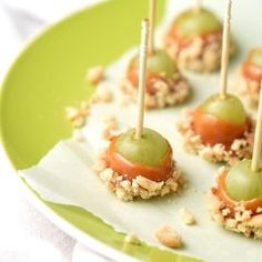 small appetizers with green olives and walnuts on a paper plate, ready to be eaten