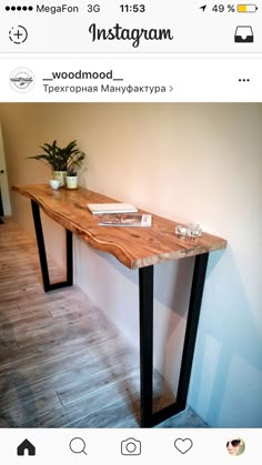 a wooden table sitting on top of a hard wood floor next to a white wall