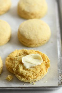 several cookies with butter on top sitting on a baking sheet