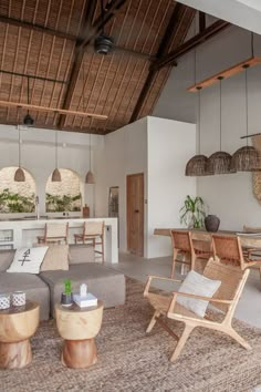 a living room filled with lots of furniture next to a dining table and kitchen area