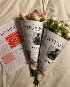 three newspapers are laying on a bed with flowers