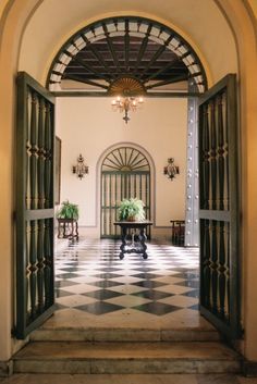 an open door leading to a foyer with potted plants