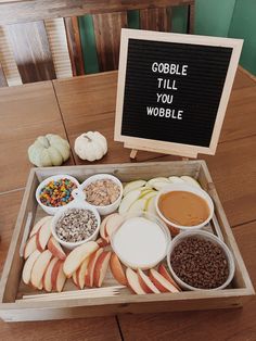 a wooden box filled with apples, cereals and other foods sitting on top of a table