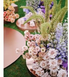 there are many different types of flowers in the vases on the grass flooring