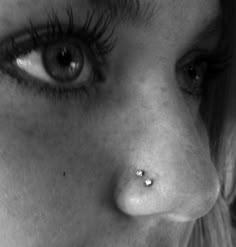 a close up of a woman's nose and nose piercing