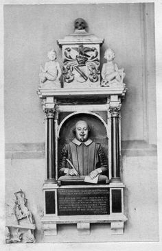 an old black and white photo of a man in front of a statue with writing on it