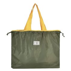 a large green bag with yellow handles on the front and bottom, sitting against a white background