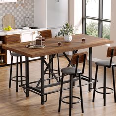 a kitchen table with four stools in front of it