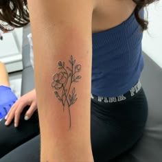 a woman with a flower tattoo on her arm