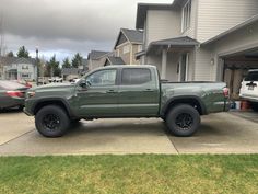 a green truck parked in front of a house