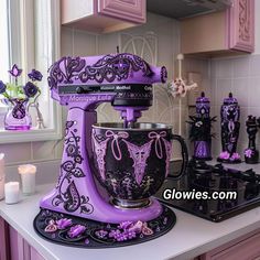 a purple mixer sitting on top of a kitchen counter next to candles and vases