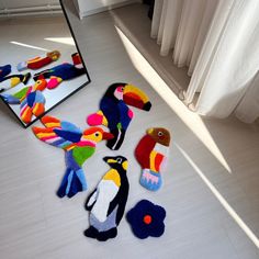 colorful birds and parrots are on the floor in front of a mirror, which is reflecting it's reflection