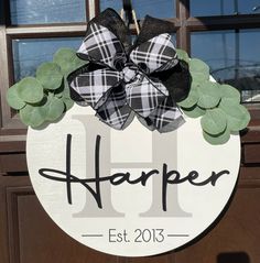 a door hanger that says harper est 2013 on it and is decorated with black and white flannel leaves