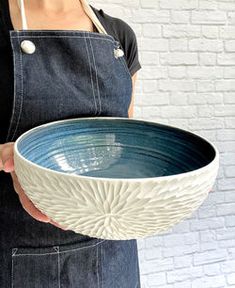 a woman in an apron holding a bowl