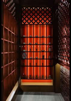 an orange display case in the middle of a room with red walls and wooden shelves