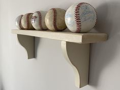 baseballs are sitting on top of a shelf