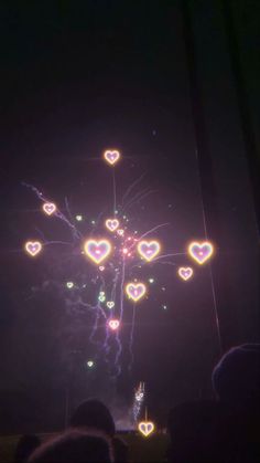 fireworks and hearts are lit up in the night sky