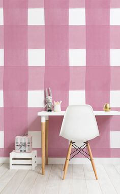 a white chair sitting in front of a pink and white checkered wallpapered desk