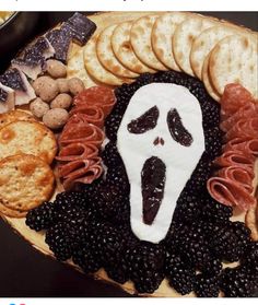 a platter with crackers, crackers and blackberries in the shape of a ghost