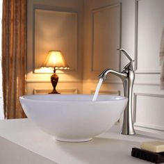 a white bowl sink sitting on top of a counter