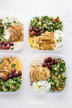 four plastic containers filled with food on top of a white countertop next to each other