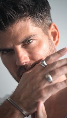 a close up of a person with a ring on his finger and wearing a watch