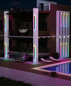 an apartment building lit up at night with pool and lounge chairs in the foreground