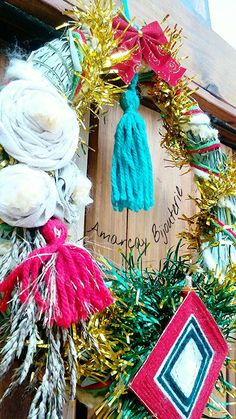 a close up of a wreath on a door with decorations around it and a name written on the front