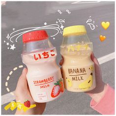 two bottles of milk are being held by someone's hands on the street with hearts drawn in the background