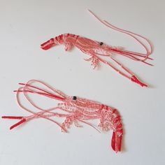 two red craws sitting on top of a white table next to each other