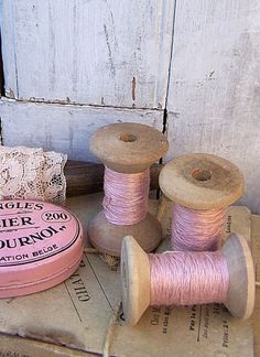 some spools of thread are sitting next to two spools of thread