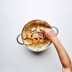 a person reaching for food in a pot