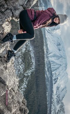 a woman standing on the edge of a cliff