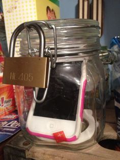 a cell phone in a jar with a lock on it