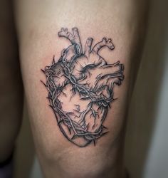 a heart tattoo with barbed wire on the side of his leg is shown in black and white