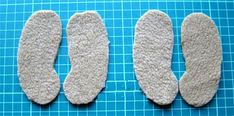 three pairs of foot pads sitting on top of a blue cutting mat next to each other