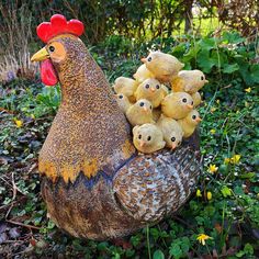 a large chicken with many smaller chickens on it's back