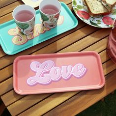 there are two trays with tea and sandwiches on the table next to each other