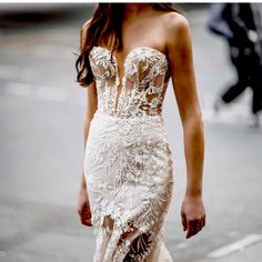 a woman is walking down the street wearing a dress with an intricate design on it