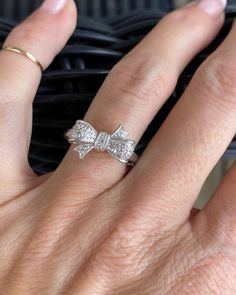 a woman's hand with a diamond bow ring