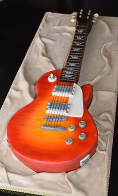 a red guitar cake sitting on top of a table