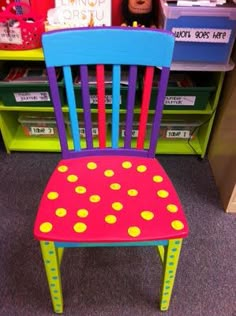 a child's wooden chair with polka dots painted on it in front of bookshelves