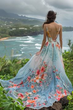 a woman in a dress looking out over the ocean