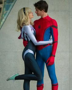 a man and woman dressed as spiderman standing next to each other