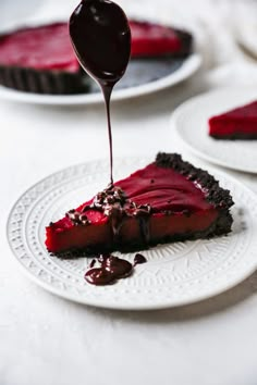 a piece of pie on a plate with chocolate sauce drizzled over it