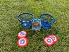 four frisbees and three baskets in the grass