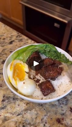 a bowl filled with meat and eggs on top of a counter